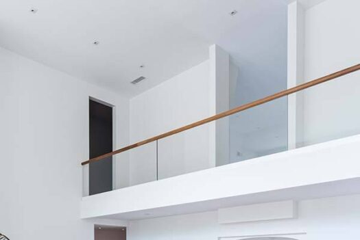 Glass railing with wooden handrail.
