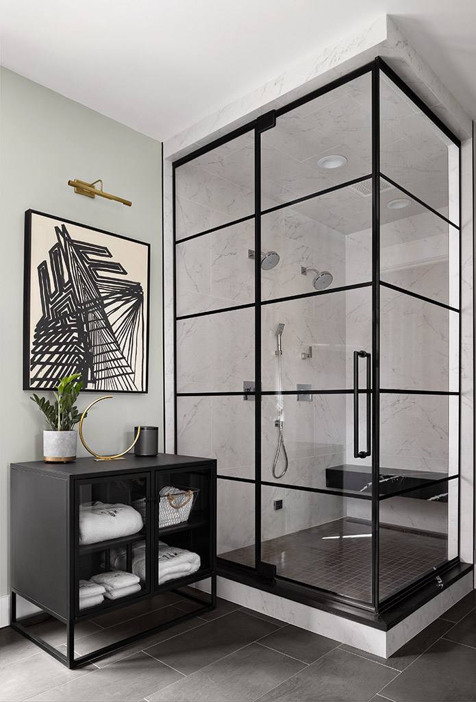Wall to wall glass shower with black accent panels resembling a window.