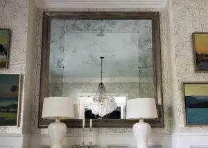 Antiqued mirror above side table in a residential home.
