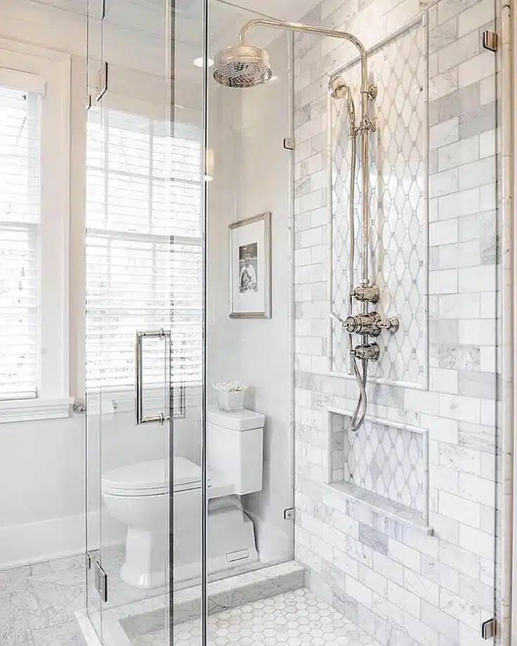 Upright shower with silver hardware and frameless glass.
