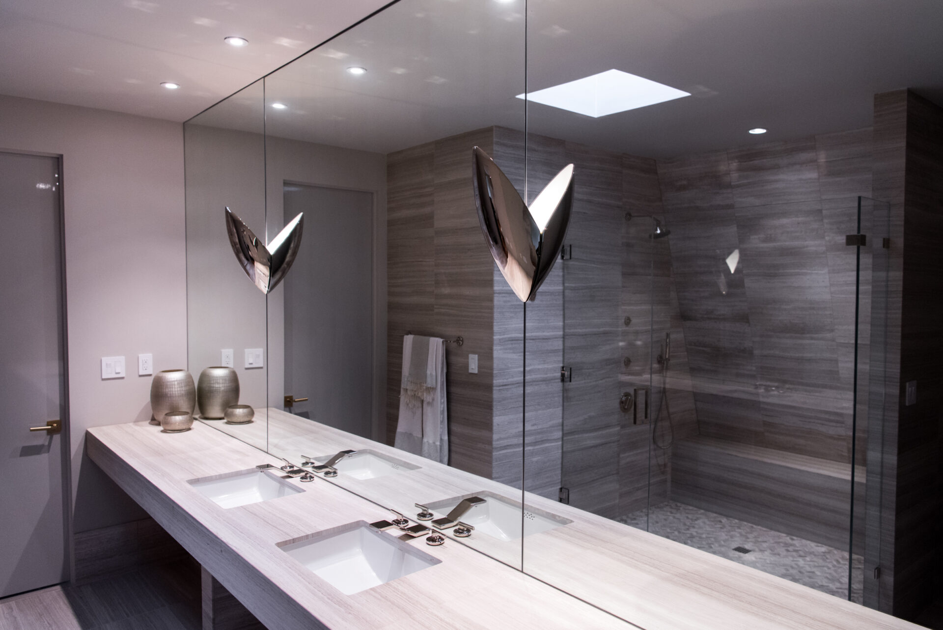 modern bathroom with mirrors and a glass shower door.