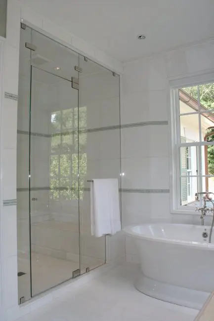 Sleek shower door with chrome clamps.