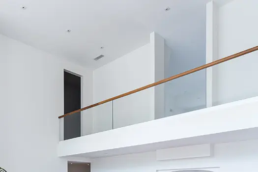 Glass railing with wooden handrail.